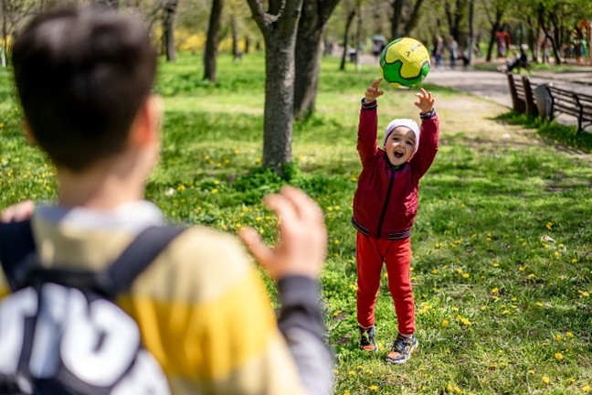 An image of children playing catch with a ball.